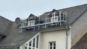 Verzinkter Dachlaufsteg mit Sicherheitsgeländer auf einem Schieferdach montiert.